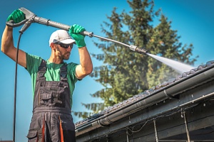 a man doing commercial power washing services on a house
