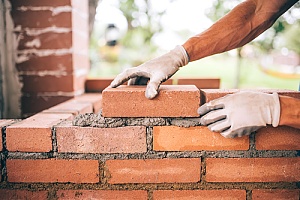 Masonry repair man laying bricks