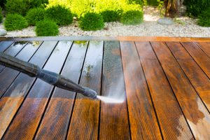 A power washer power washing a wooden surface