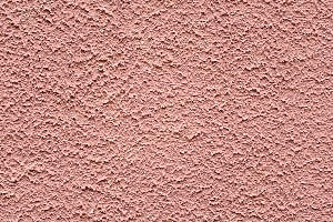 surface of rough pink stucco wall