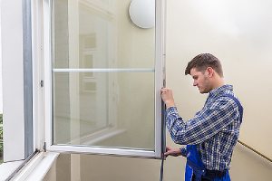 A repairman applying waterproofing sealant on window. Interior caulking can improve air quality