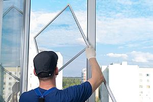 Worker installing Window. This is also refer to as window glazing