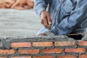 worker building wall with cament and brick on a masonry repair