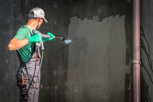 building elevation Commercial Pressure Washing Services by worker with power washer