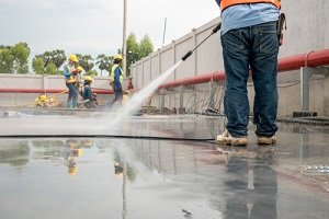 construction worker concrete floor cleaning with high Pressure Wash water jet