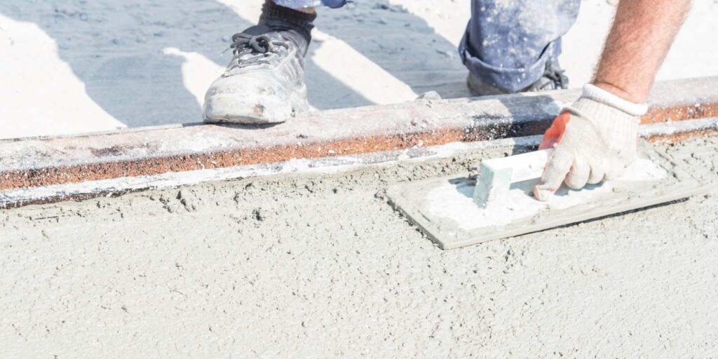 A mason is patching concrete with the use of a float