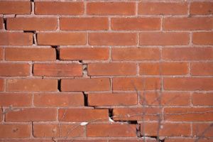 Cracked and damaged mortar of a brick wall