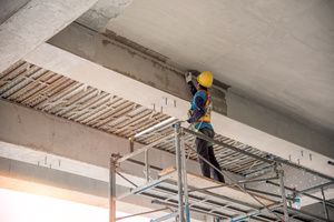 A mason repairing cracks of a giant ceiling