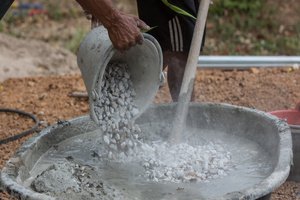A mason preparing mortar in a bowl