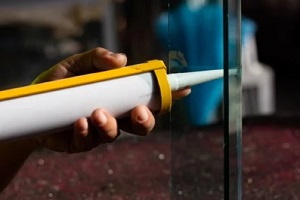 applying caulk in glass