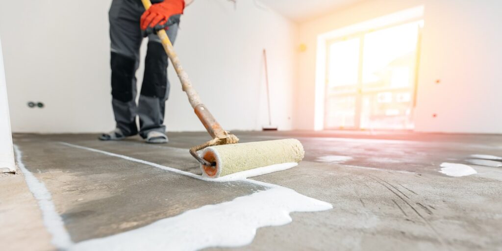 worker use primer on concrete floor before laying tiles in New Jersey