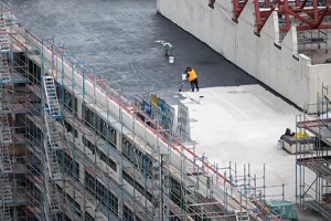 PA roofer painting flat roof of a commercial building top
