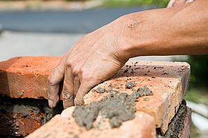 Hand removing old brick for masonry restoration in South Philadelphia